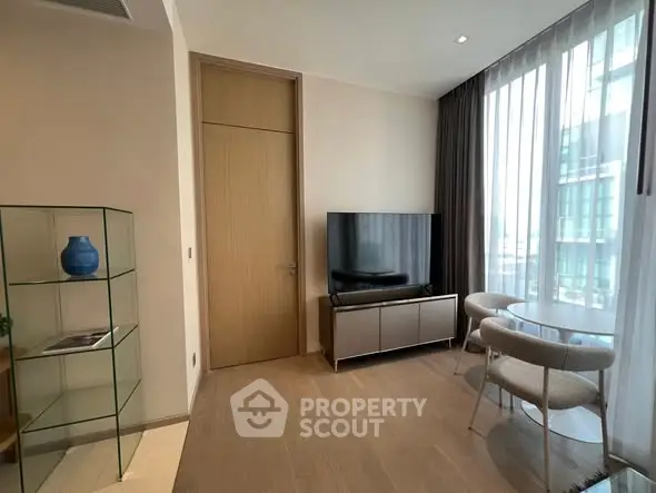 Modern living room with sleek TV, glass shelves, and elegant dining set