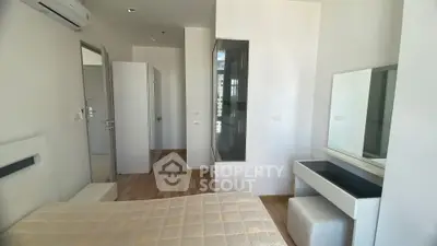 Modern bedroom with sleek furniture and natural light, featuring a minimalist design and hardwood flooring.