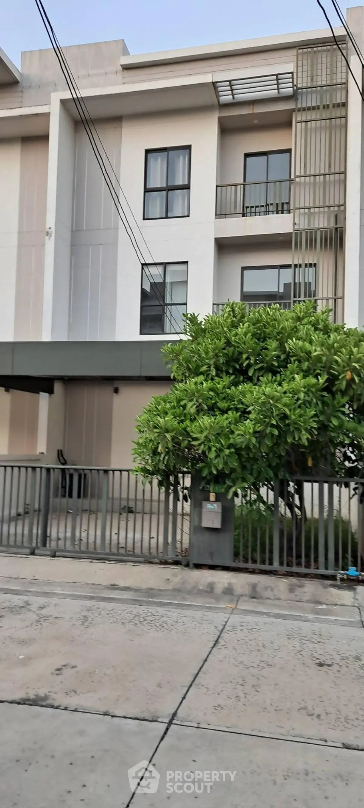 Modern townhouse exterior with sleek design and lush greenery in a desirable neighborhood.