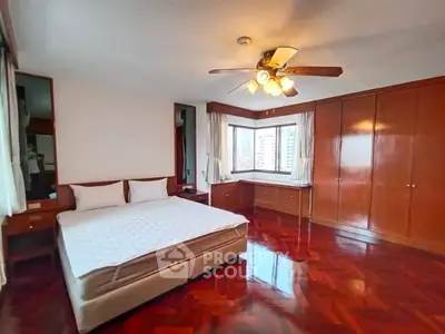 Spacious bedroom with wooden flooring and built-in wardrobe in modern apartment