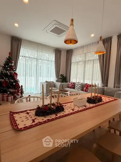 Spacious living room with festive decor and modern lighting, perfect for holiday gatherings.