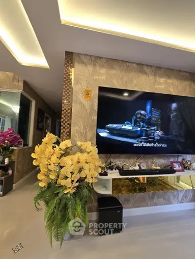 Luxurious living room with modern decor, large TV, and elegant lighting.
