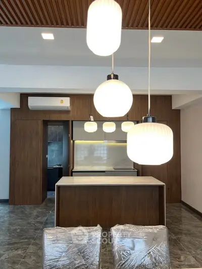 Modern kitchen with stylish pendant lights and sleek wooden cabinetry