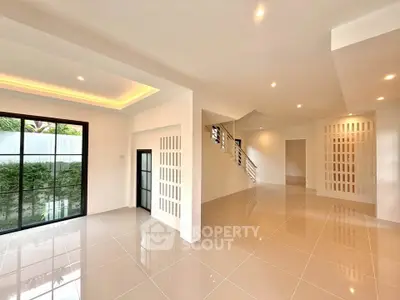 Spacious modern living room with large windows and elegant tile flooring