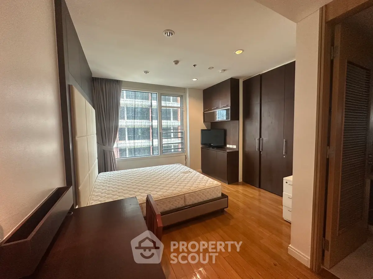 Spacious bedroom with modern furnishings and large window view