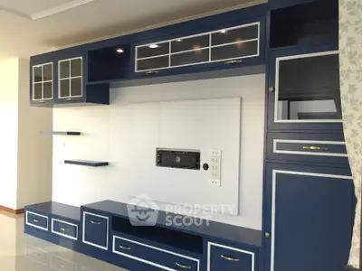Modern living room with stylish blue built-in entertainment unit and elegant cabinetry.
