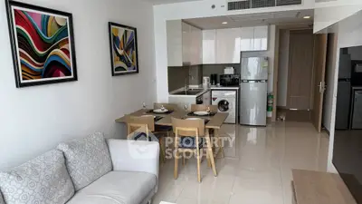 Modern open-plan living room and kitchen with stylish decor and appliances.