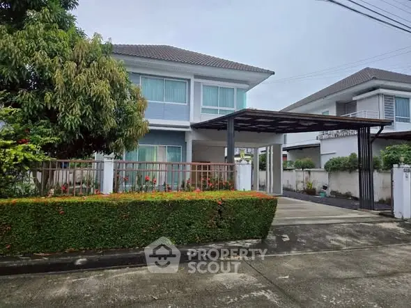 Charming two-story house with lush garden and spacious driveway in a serene neighborhood.