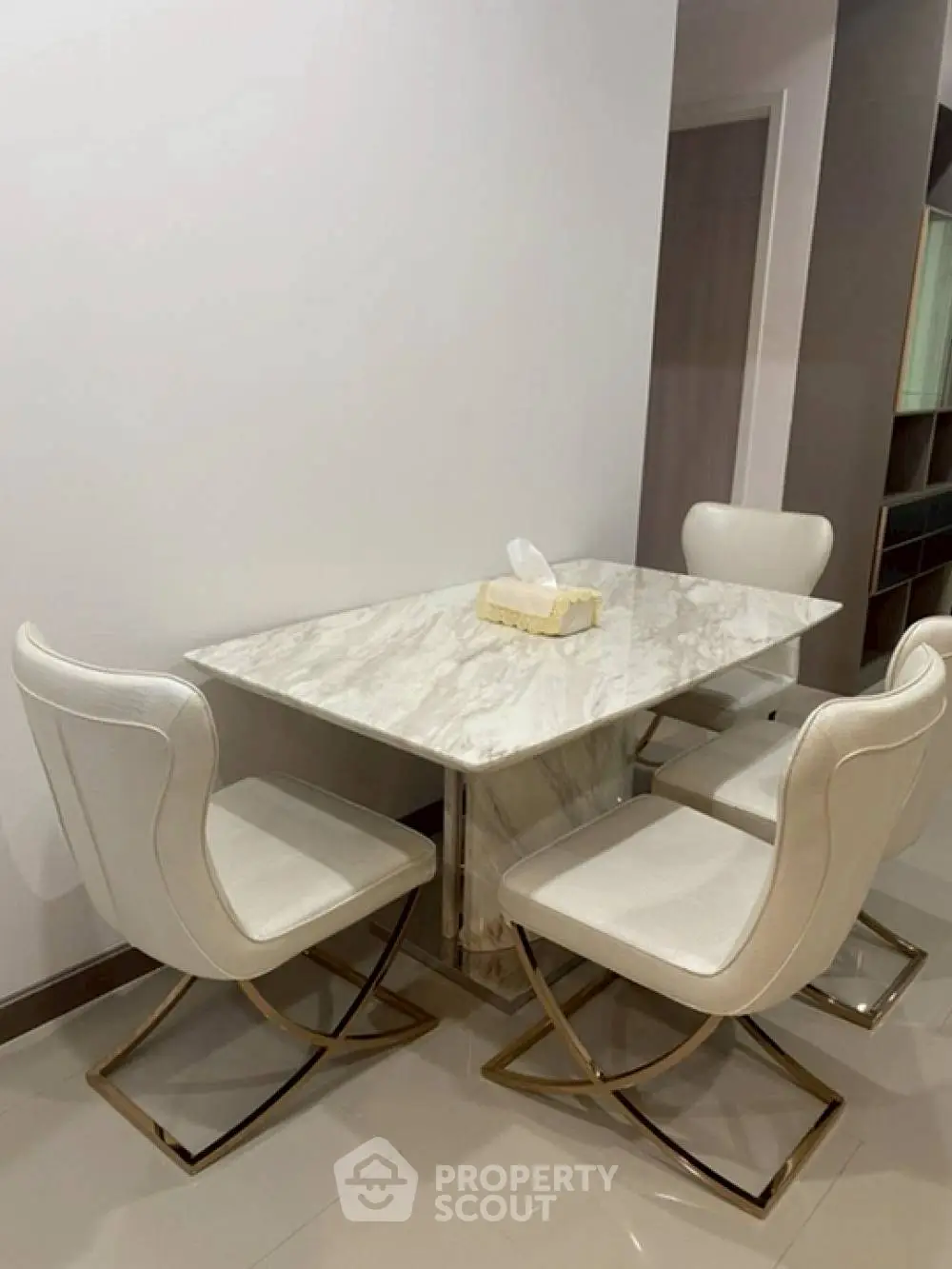 Elegant dining area with marble table and modern chairs in a stylish home.