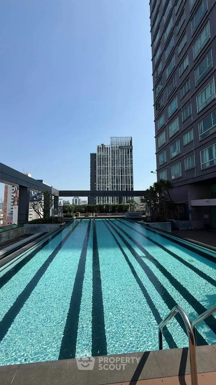 Luxurious high-rise building with a stunning rooftop pool and city views, perfect for urban living.