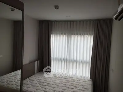 Cozy bedroom with large window and modern furnishings, perfect for relaxation and comfort.
