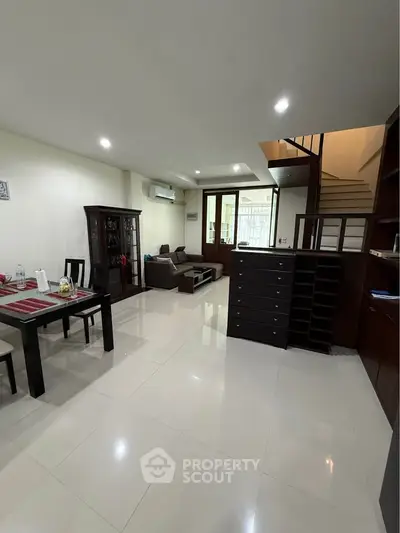 Spacious living room with modern furniture and dining area, perfect for family gatherings.