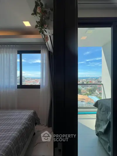 Modern bedroom with balcony offering stunning city view and natural light.