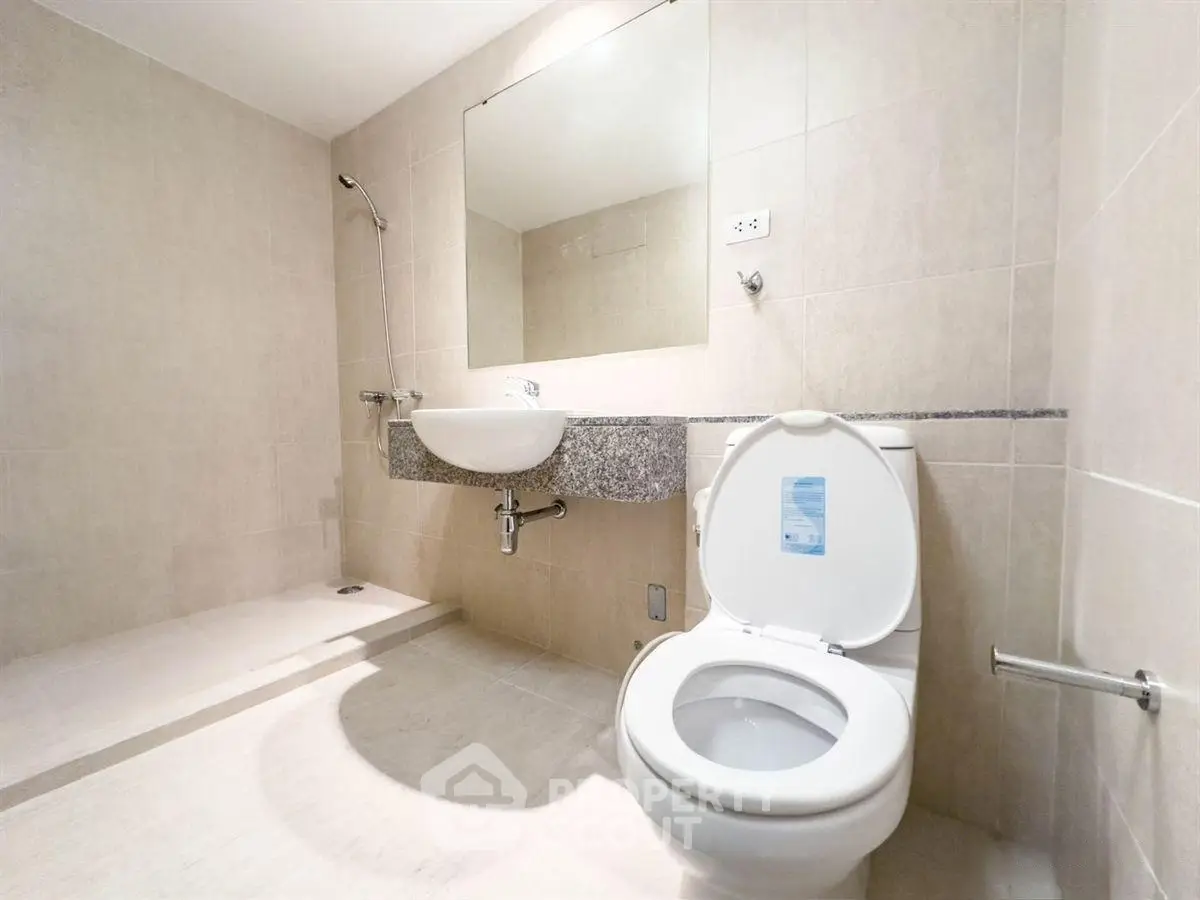Modern bathroom with sleek fixtures and spacious shower area.