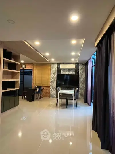 Modern living room with sleek design, large TV, and elegant lighting, perfect for contemporary living.
