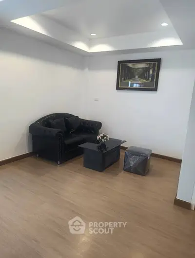 Spacious living room with elegant black sofa and modern decor