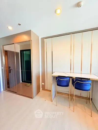 Modern apartment interior with stylish dining area and mirrored closet doors.