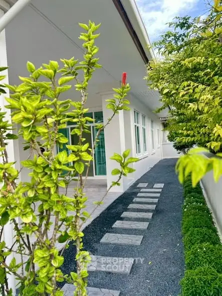 Charming exterior walkway with lush greenery and modern design elements.