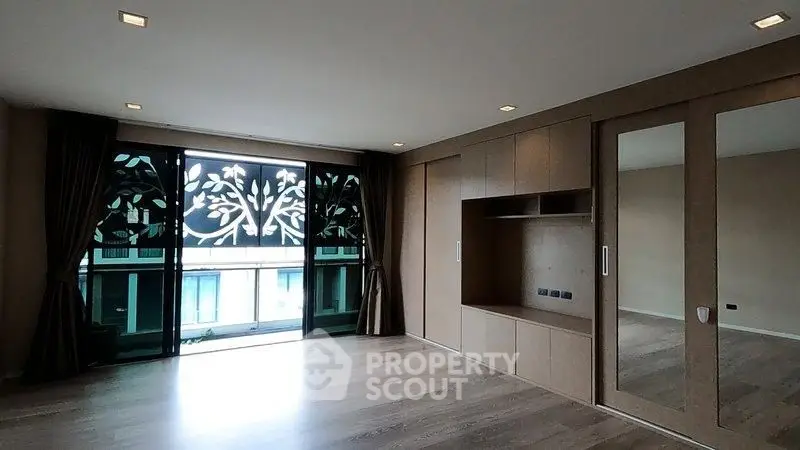 Spacious modern living room with large windows and elegant wooden flooring.