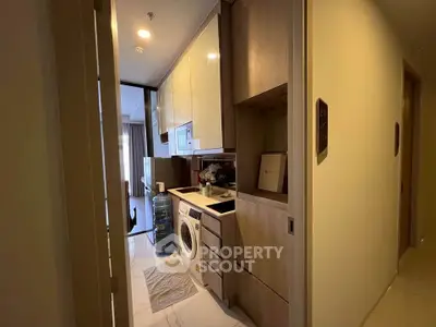 Modern apartment hallway with built-in laundry area and storage cabinets