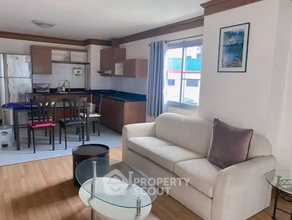 Spacious open-layout living room with modern kitchen and cozy seating area.