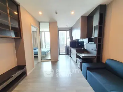 Modern apartment interior with sleek design and open layout, featuring a cozy living area and a glimpse of the bedroom.