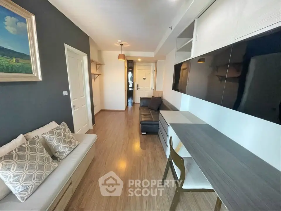 Modern living room with sleek furniture and wooden flooring in a stylish apartment.