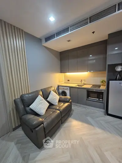 Modern kitchen with sleek cabinetry and cozy seating area in stylish apartment.