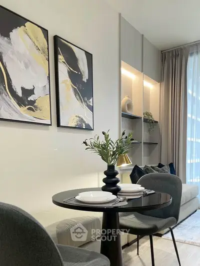 Modern living room with elegant decor and stylish furniture, featuring abstract art and cozy seating area.