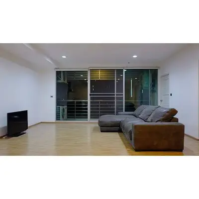 Spacious living room with modern sofa and large windows in a contemporary apartment.