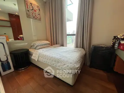 Cozy bedroom with modern decor and city view, featuring a single bed and stylish furnishings.