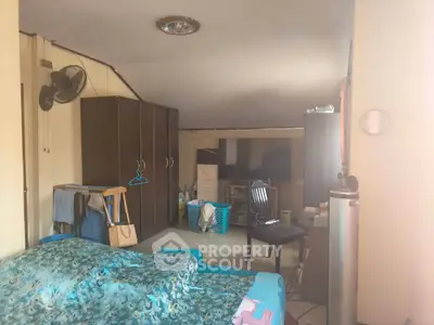 Cozy attic bedroom with wardrobe and TV, perfect for compact living.