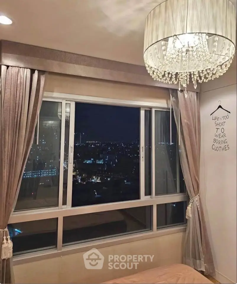 Chic bedroom with stunning night city view and elegant chandelier.
