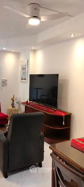 Spacious living room with modern TV setup and cozy seating area.