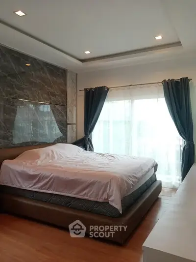 Luxurious bedroom with elegant decor and large windows for natural light.