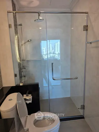 Modern bathroom with glass shower and city view