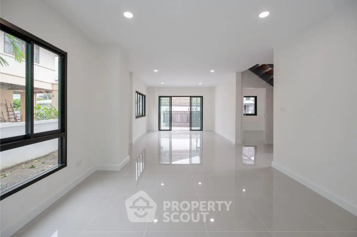 Spacious modern living room with glossy tile flooring and large windows