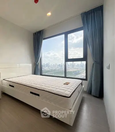 Modern bedroom with stunning city view from large window, featuring sleek design and natural light.