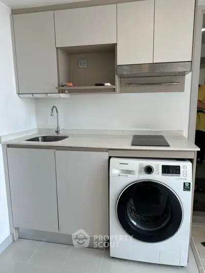 Modern compact kitchen with integrated washing machine and sleek cabinetry