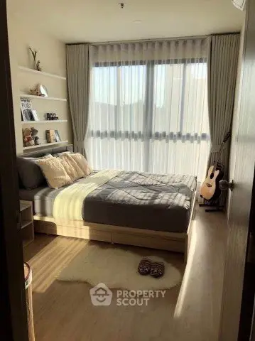 Cozy bedroom with large window, modern decor, and natural light