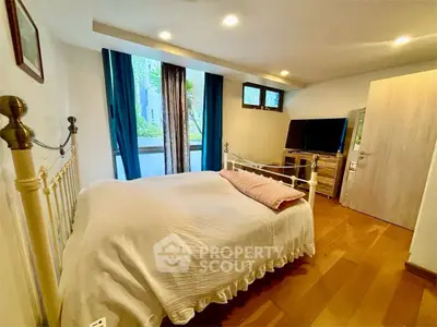 Cozy bedroom with wooden flooring and natural light