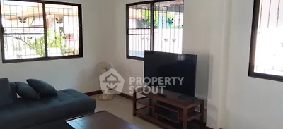 Spacious living room with modern sofa and large TV, perfect for relaxation.