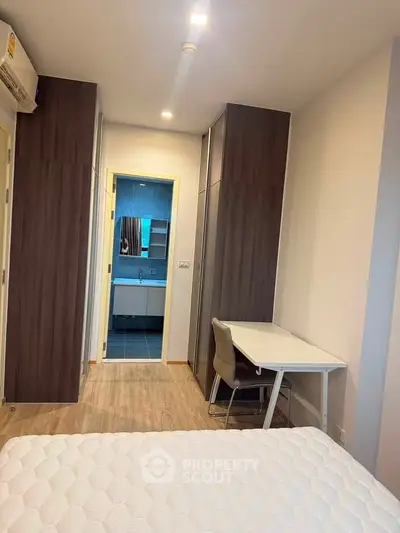 Modern bedroom with study area and view into bathroom