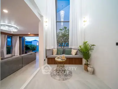 Luxurious modern living room with elegant decor and large windows offering natural light.
