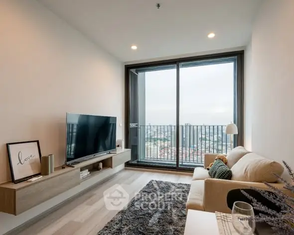 Modern living room with large TV and balcony view in high-rise apartment.