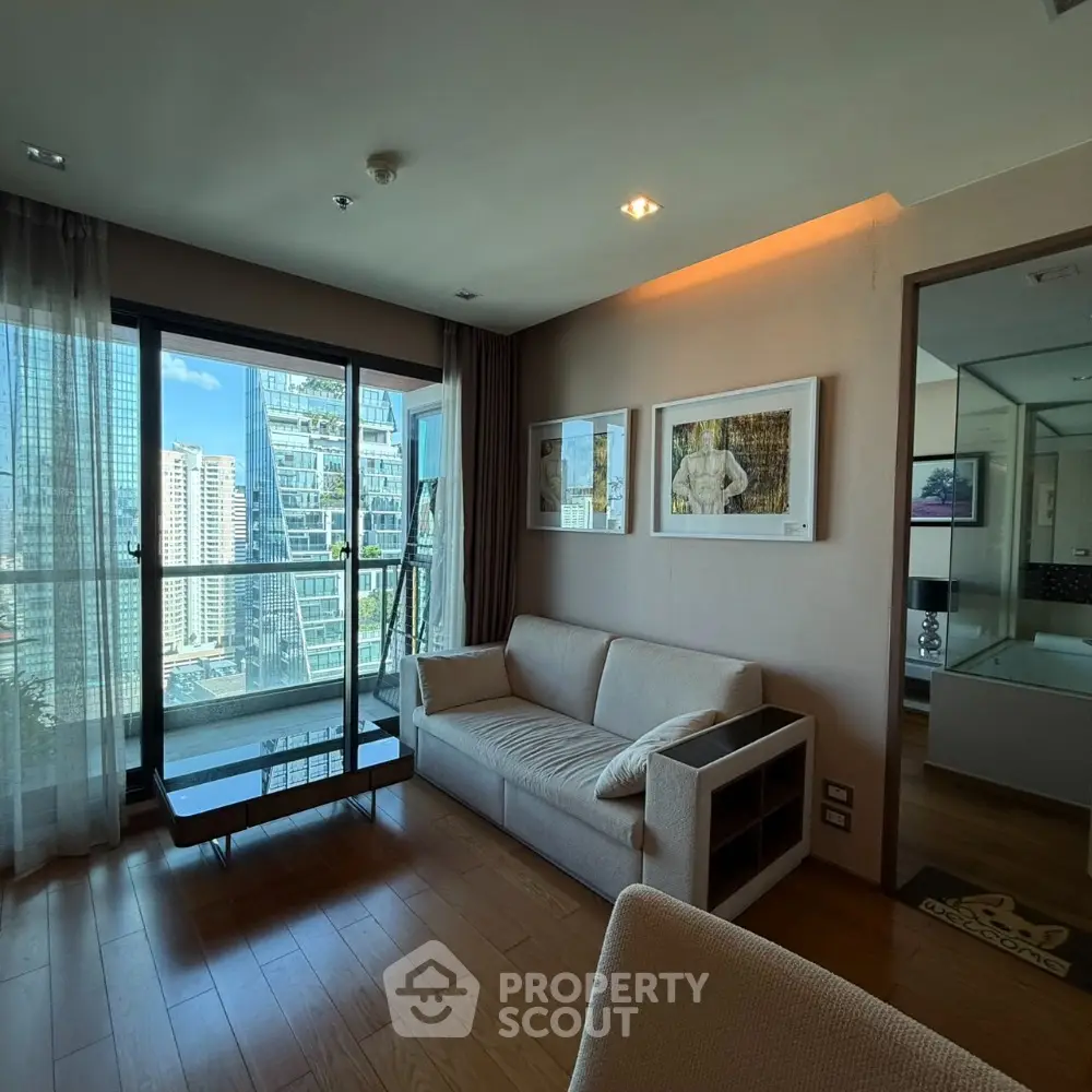 Modern living room with city view, featuring sleek furniture and large windows for natural light.