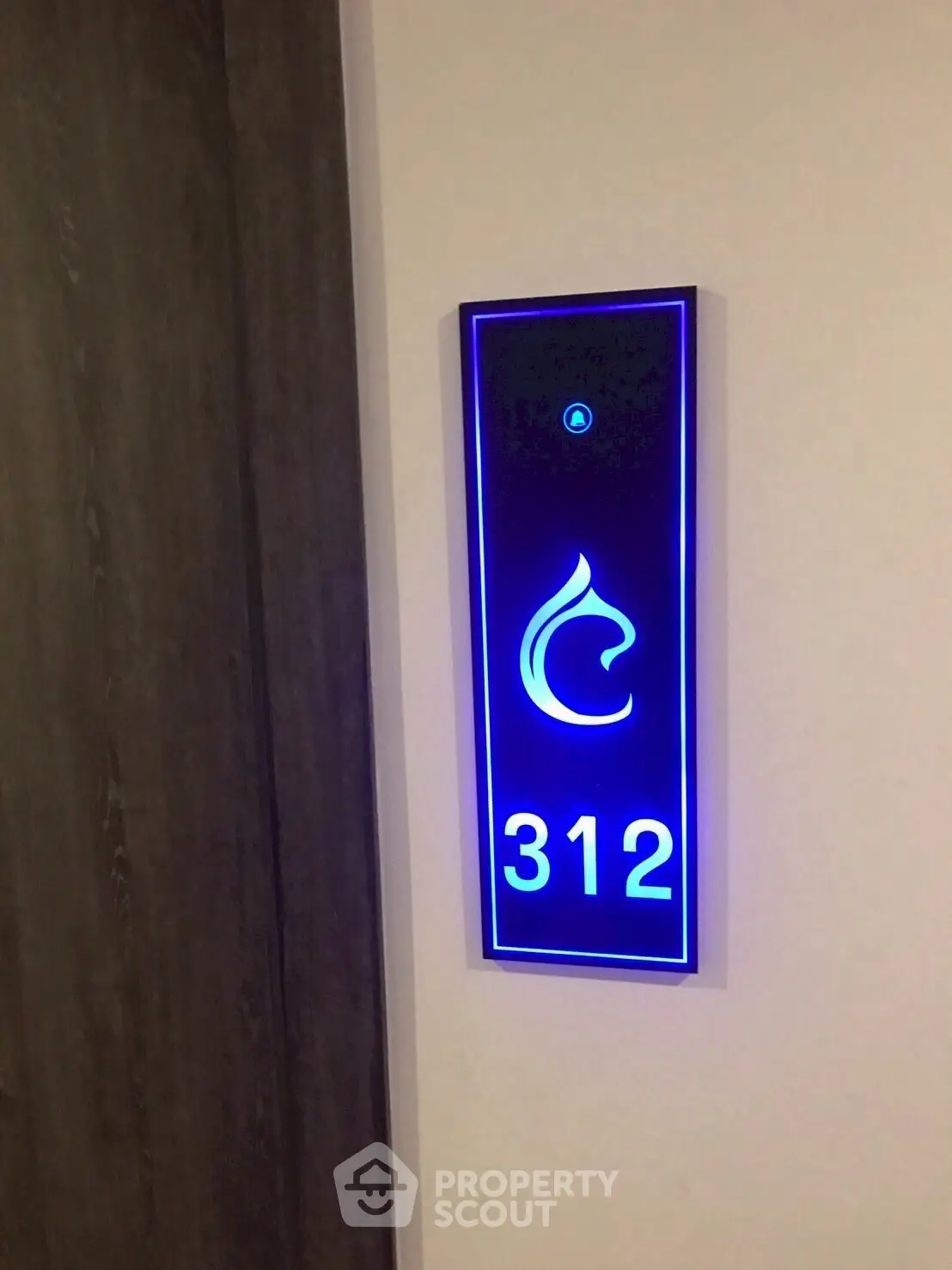 Modern illuminated room number sign with sleek design in hotel or apartment building.