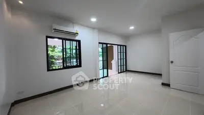 Spacious empty room with large windows and glossy tiled floors