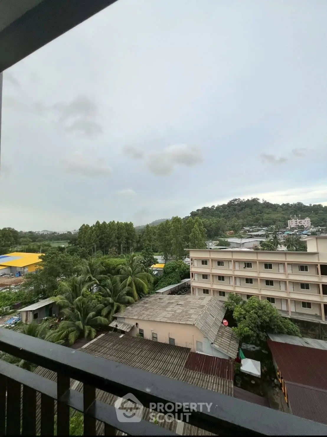 Scenic view from balcony overlooking lush greenery and urban landscape