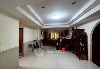 Spacious living room with elegant ceiling design and ample natural light.